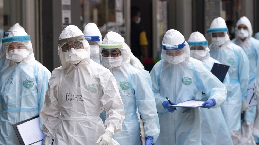 Medical workers in protective suits entering a building under lockdown in downtown Kuala Lumpur, Malaysia, on Tuesday, April 7, 2020. The Malaysian government issued a restricted movement order to the