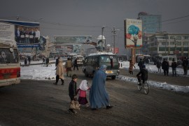 A woman with her children crosses a busy street in the capital Kabul, February 4, 2020. Kabul has become one of the most polluted cities in the world. For several months per year, especially in the wi