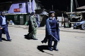 Kenyan police carrying batons and teargas patrol looking for people out after curfew in the Kibera slum, or informal settlement, of Nairobi, Kenya Sunday, March 29, 2020. The curfew which runs from 7p
