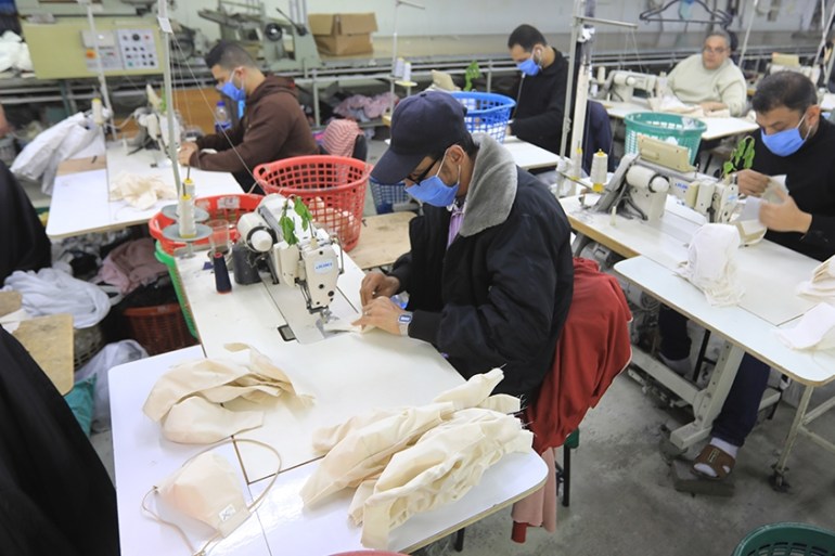 Palestinian workers sew medical clothing and protective masks at a factory east of Gaza city, on March 25, 2020, amid the COVID-19 epidemic. - The Queen Tex factory in the Gaza Strip used to specialis