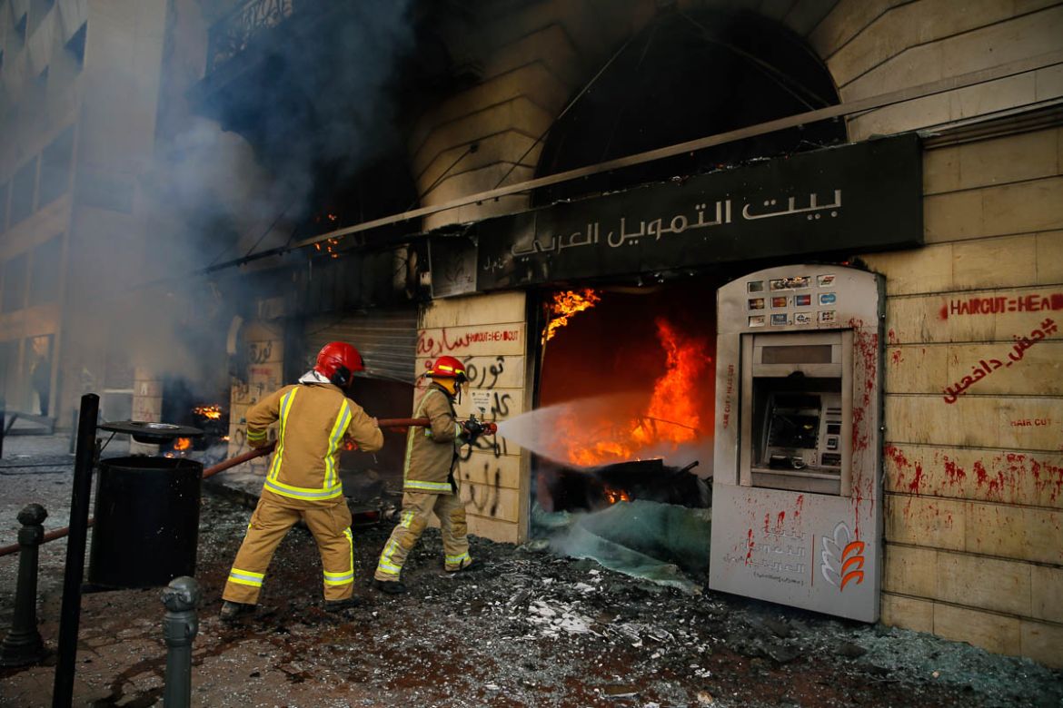 Firefighters extinguish a fire at a branch of the Credit Libanais Bank that was burnt by anti-government protesters, in the northern city of Tripoli, Lebanon, Tuesday, April 28, 2020. Hundreds of angr