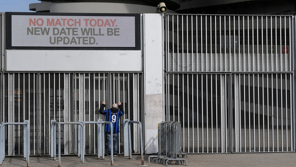 A man stands outside the San Siro stadium after the Inter Milan v Sampdoria Serie A match was cancelled due to an outbreak of the coronavirus in Lombardy and Veneto, in Milan