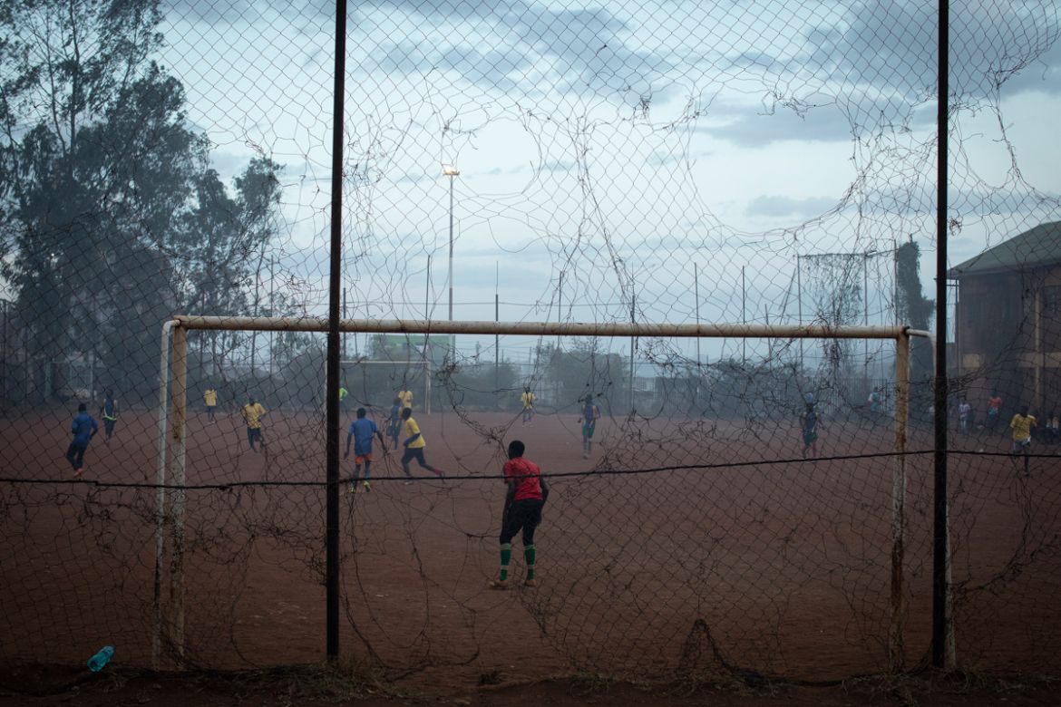 Young men play a football match in a pitch filled with smoke blowing from the Dandora dumpsite, in the slum of Korogocho in the capital Nairobi, Kenya, February 20, 2019. Nearly one million people liv