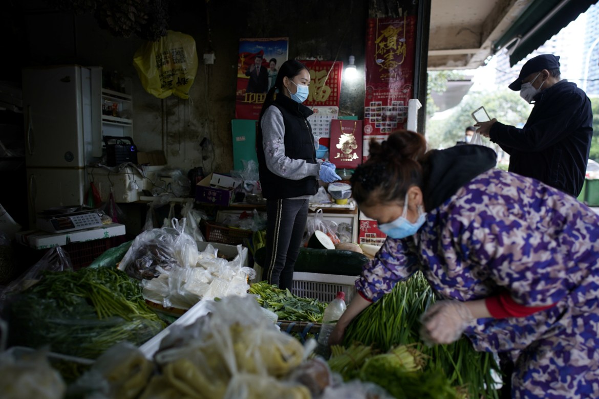 People wearing face masks buy vegetables at a street market in Wuhan, Hubei province, the epicentre of China''s novel coronavirus disease (COVID-19) outbreak, April 6, 2020. RUETERS/Aly Song - RC2RYF9X