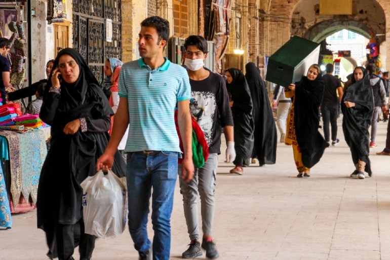 RAN-HEALTH-VIRUS Iranians, some wearing personal protective equipment, walk past shops in the southeastern city of Kerman on April 11, 2020, amid the coronavirus (COVID-19) pandemic.