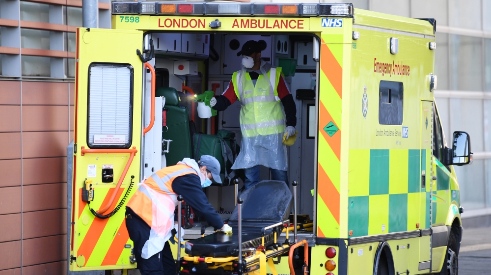 Staff wearing personal protective equipment (PPE) disinfect a London Ambulance outside The Royal London Hospital in east London on April 19, 2020. The number of people in Britain who have died in hosp