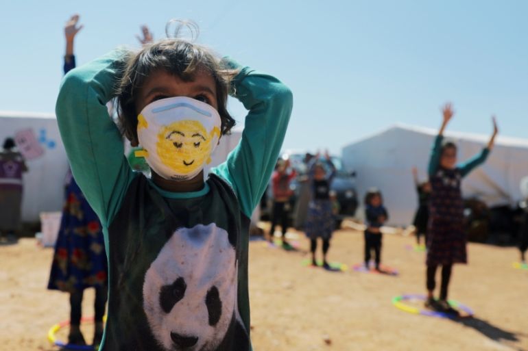 A displaced girl wears a face mask as she takes part in an event organzied by Violet Organization