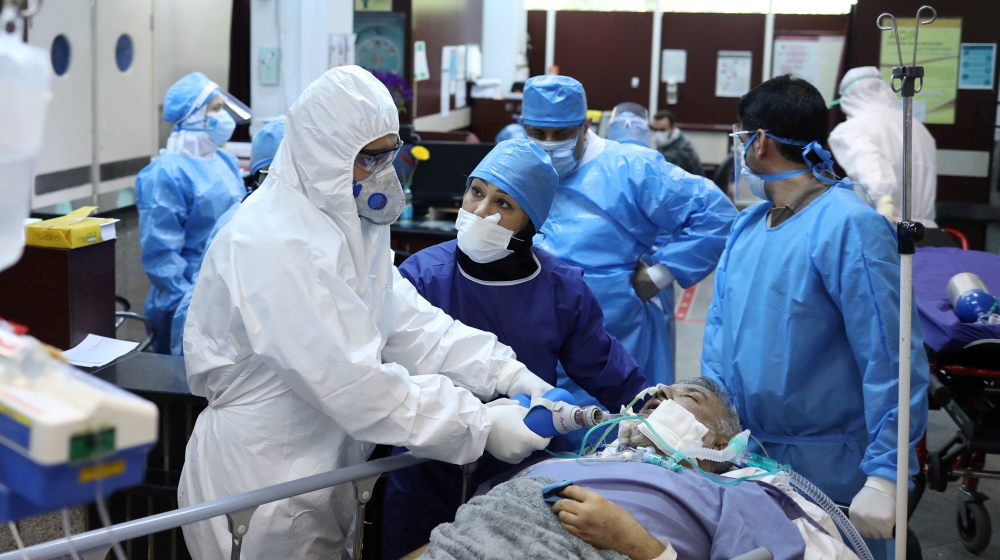 Emergency medical staff and nurses wearing protective suits, help while transferring a patient with coronavirus disease (COVID-19) to Masih Daneshvari Hospital, in Tehran, Iran March 30, 2020. WANA (W
