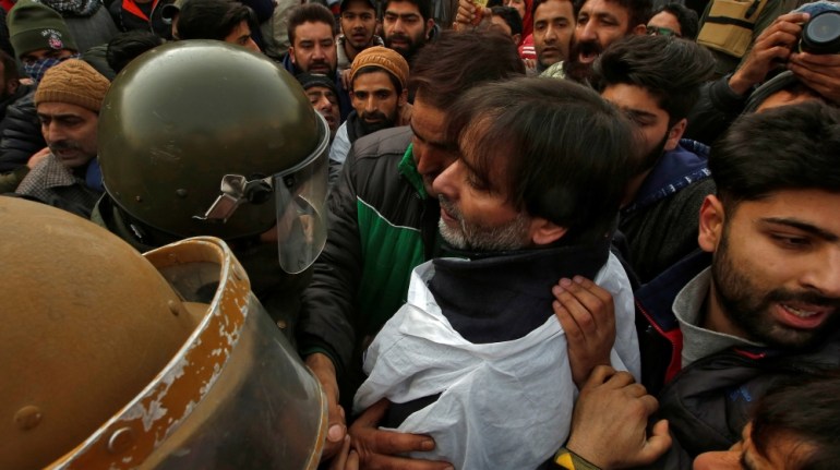 Indian police officers try to detain Mohammad Yasin Malik, Chairman of JKLF, during a protest march in Srinagar