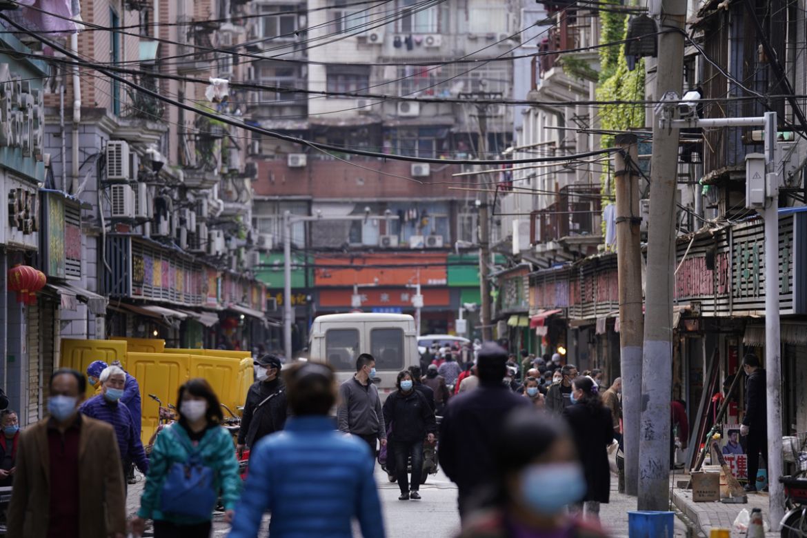 People wearing face masks walk on a street market in Wuhan, Hubei province, the epicentre of China''s novel coronavirus disease (COVID-19) outbreak, April 6, 2020. RUETERS/Aly Song - RC2RYF9CFNVJ