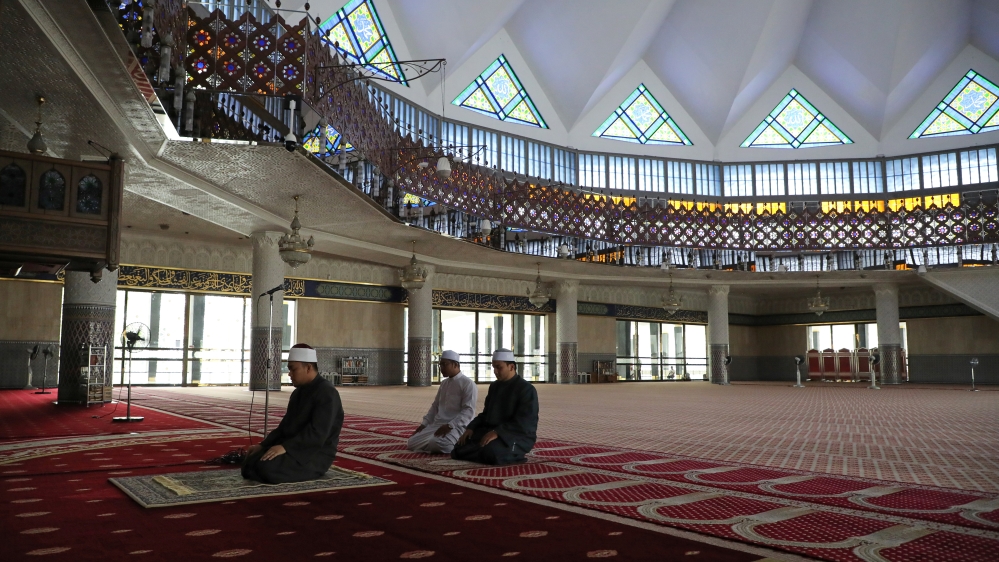 A Muslim Imam leads a prayer inside empty National Mosque