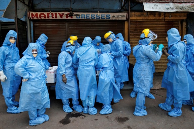 Doctors wearing protective gear gather to take swabs from the residents to test for coronavirus disease (COVID-19) at a residential area in Ahmedabad, India, April 8, 2020. REUTERS/Amit Dave