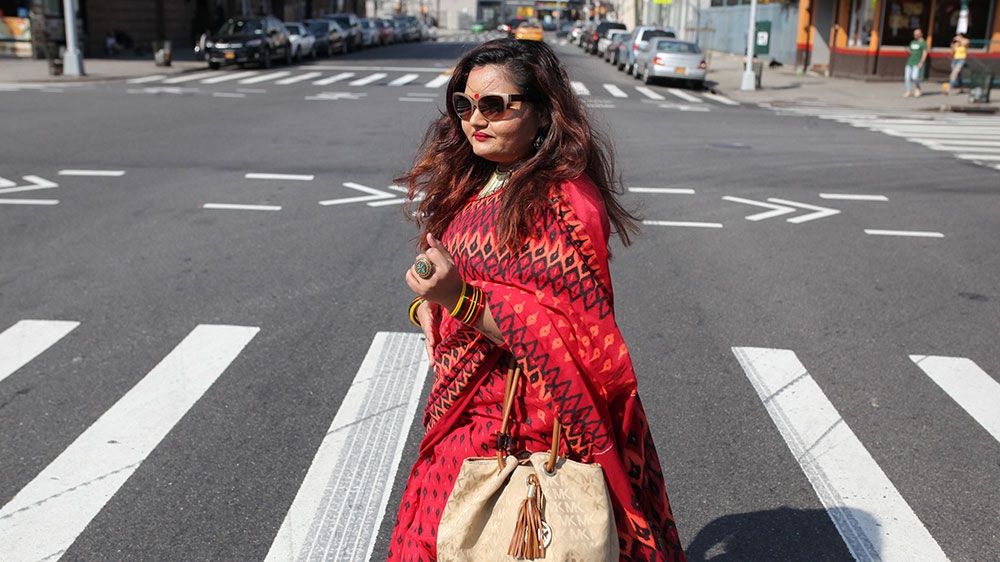 A Bangladeshi woman crosses the street in Manhattan, New York [File: Anik Rahman/Reuters]