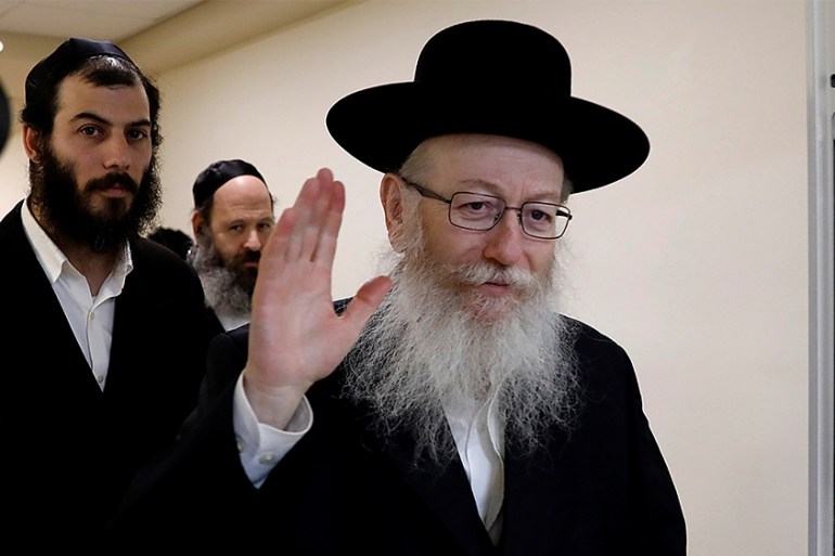 Israeli Health Minister Yakov Litzman, a rabbi from the United Torah Judaism party, waves to journalists after handing in his resignation to Prime Minister Benjamin Netanyahu, during the weekly cabine