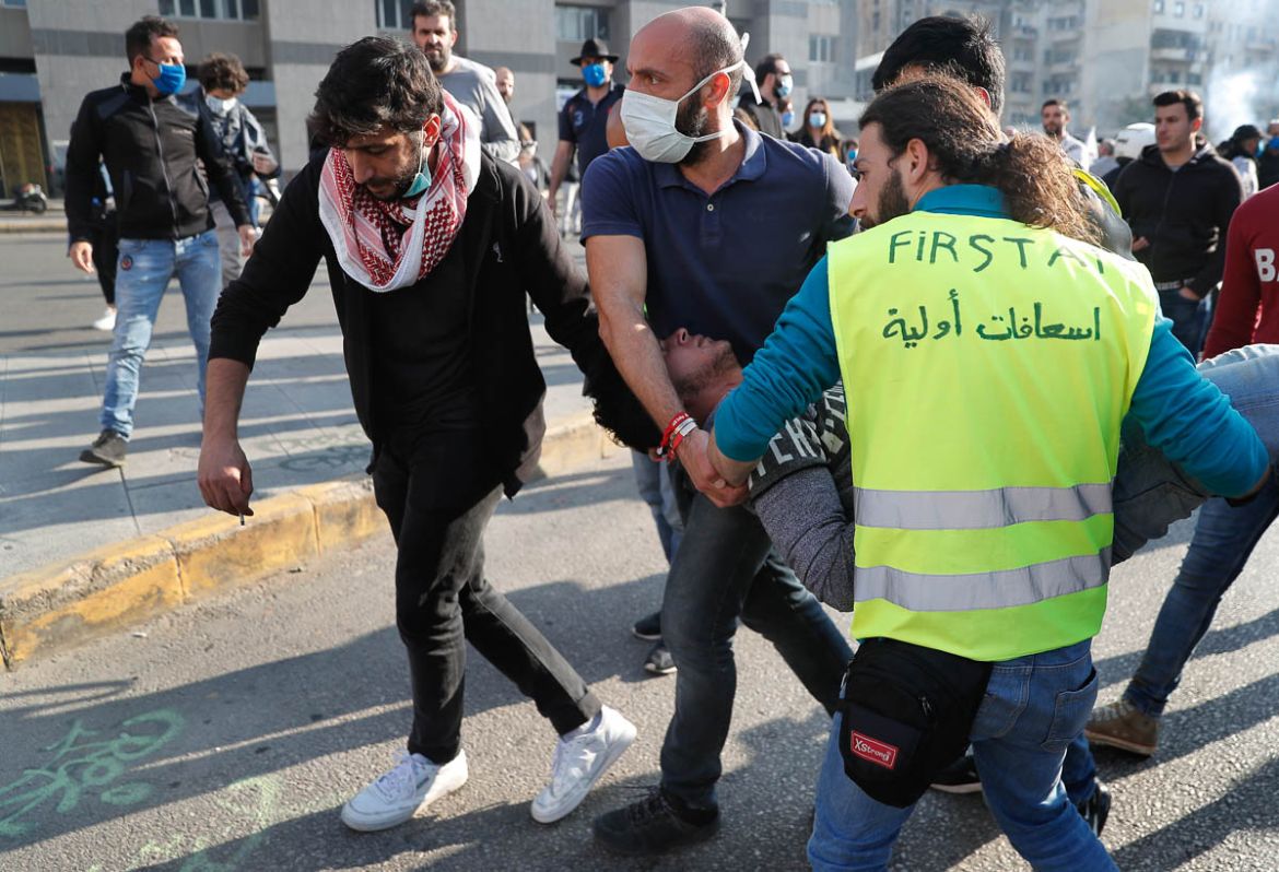 People carry an injured man during a protest against the deepening financial crisis, in Beirut, Lebanon, Tuesday, April 28, 2020. Hundreds of protesters in Lebanon''s northern city of Tripoli set fire