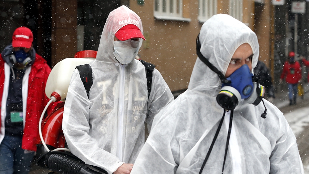 epa08318157 Employees of the local cleaning company  'Deratizer' wearing face masks with filters disinfect a building in Sarajevo, Bosnia and Herzegovina, 24 March 2020. Several European countries hav