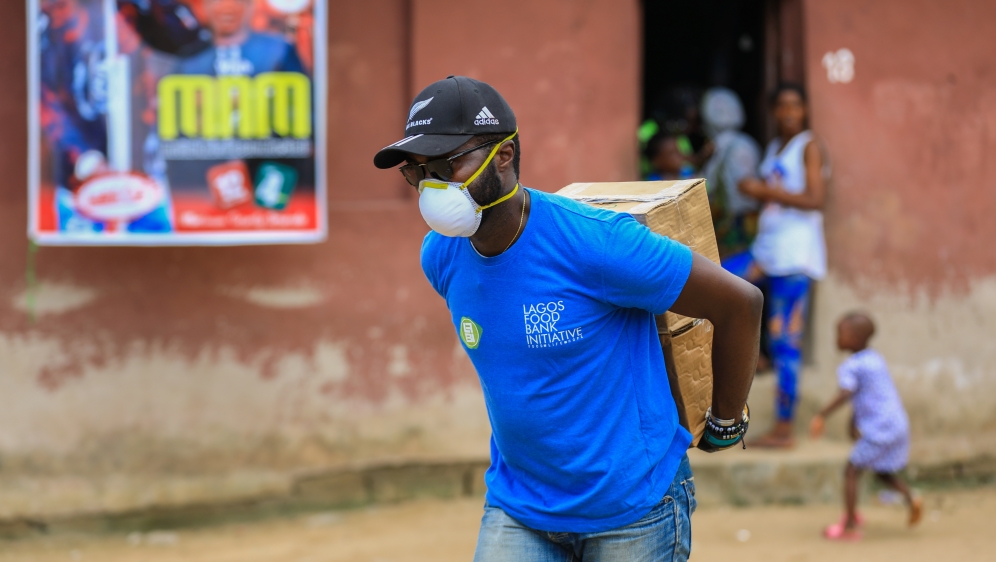 A volunteer carries food parcels to distribute to vulnerable residents, during a lockdown by the authorities in efforts to limit the spread of the coronavirus disease (COVID-19), in Lagos