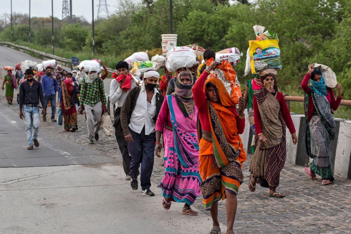 Friends and relatives of Kushwaha family who work as migrant workers walk along a road to return to their villages, during a 21-day nationwide lockdown to limit the spreading of coronavirus, in New De
