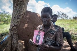Jeanette Aromorach holds a picture of her son, 12-year-old Stewart Rubamga-Kwo, who died on March 31, unable to reach hospital because of Uganda''s transport ban. [Sally Hayden/Al Jazeera]