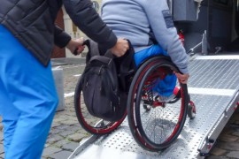 Disabled person in wheelchair using van ramp