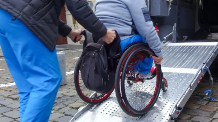 Disabled person in wheelchair using van ramp