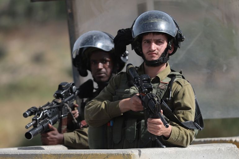 HEBRON, WEST BANK - MAY 13: Israeli soldiers stand guard at the entrance of Al-Fawar refugee camp after a raid, where 15 years old Palestinian Zaid Fadl Qaisia shot in the head by an Israeli soldier,