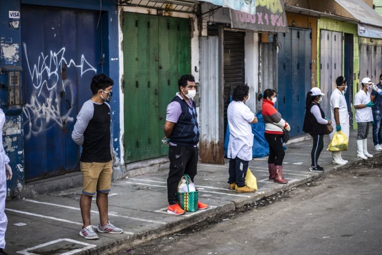 Employees of the Ciudad de Dios market wait respecting safety distances to be tested by workers of the Health Ministry to discard COVID-19 in Lima on May 11, 2020. ERNESTO BENAVIDES / AFP