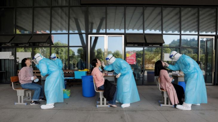 Medical workers collect swabs from high school teachers for nucleic acid tests at a school in Yichang
