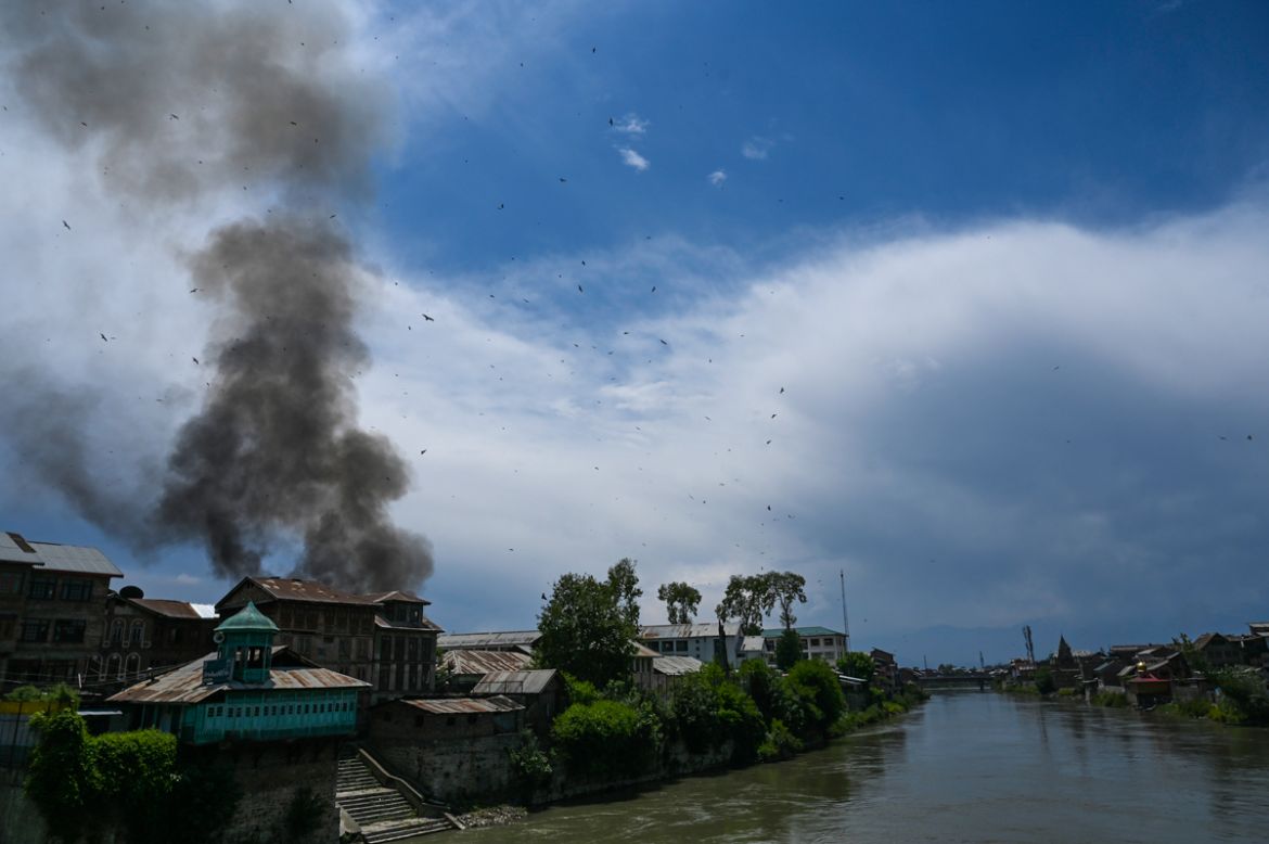 Smoke rises from a house at a site of a gun battle between suspected militants and government forces in downtown Srinagar on May 19, 2020. - Two Kashmir militants including a key rebel leader were kil