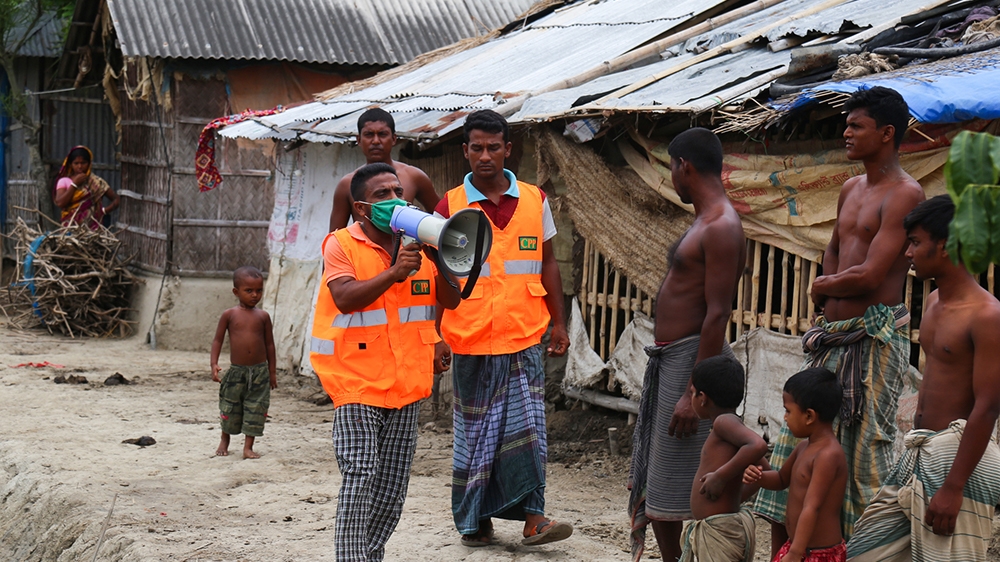 A Cyclone Preparedness Programme (CPP) volunteer uses a megaphone to urge residents to evacuate to shelters ahead of the expected landfall of cyclone Amphan in Khulna on May 19, 2020. - India and Bang