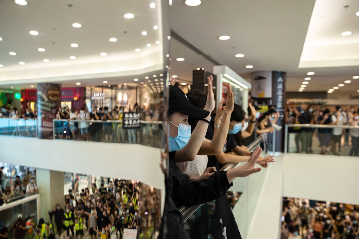 epa08413028 Protesters gesture during a ''sing with you'' protest at a shopping mall in Hong Kong, China, 10 May 2020. A heavy police presence in Tsim Sha Tsui thwarted plans for a pro-independence marc