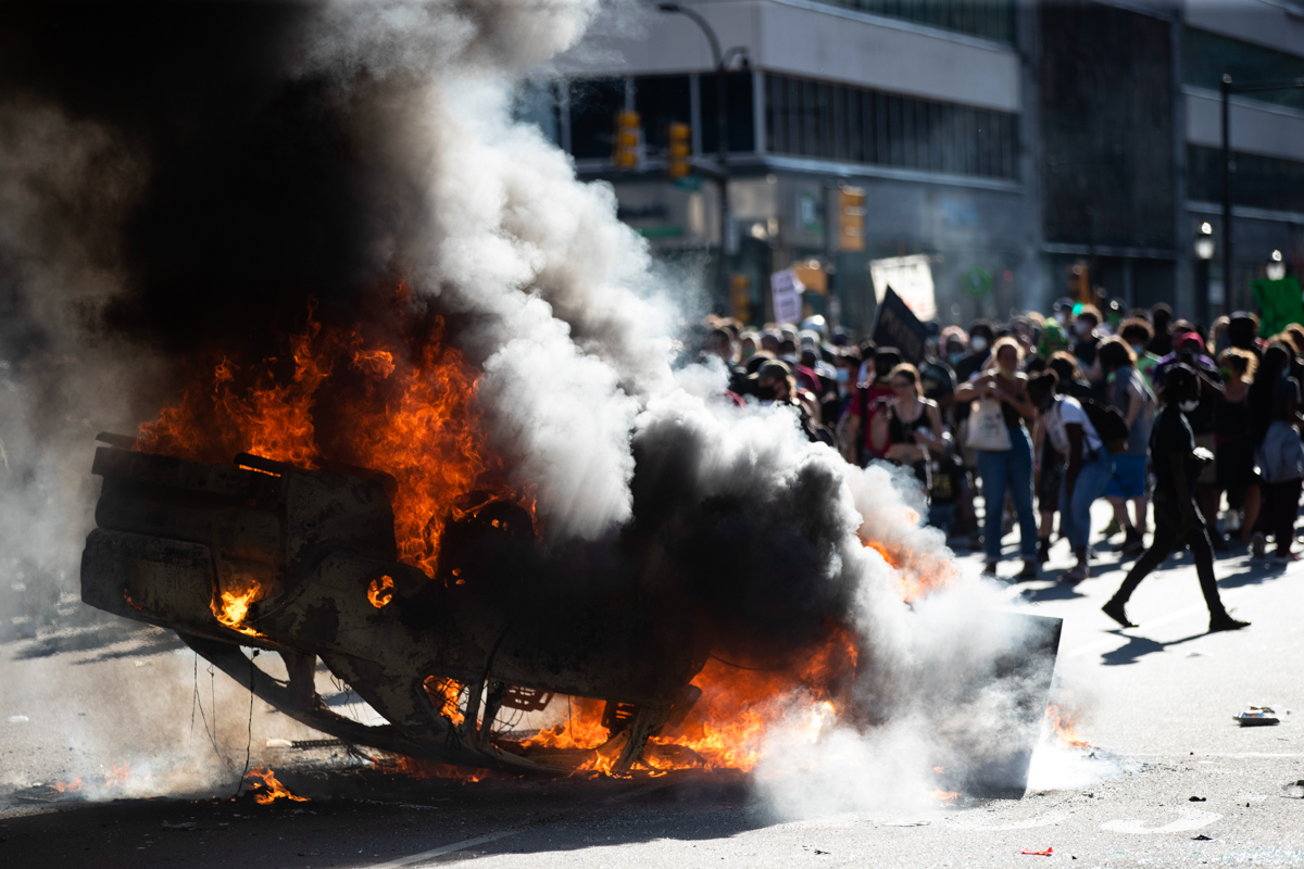Smoke rises from a fire on a police cruiser in Center City during the Justice for George Floyd Philadelphia Protest on Saturday, May 30, 2020, in Philadelphia. Demonstrators took to the streets across