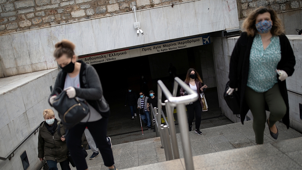 Commuters wearing protective face masks exit the metro station on Syntagma square, on the first day of easing of a nationwide lockdown against the spread of coronavirus disease (COVID-19), in Athens, 