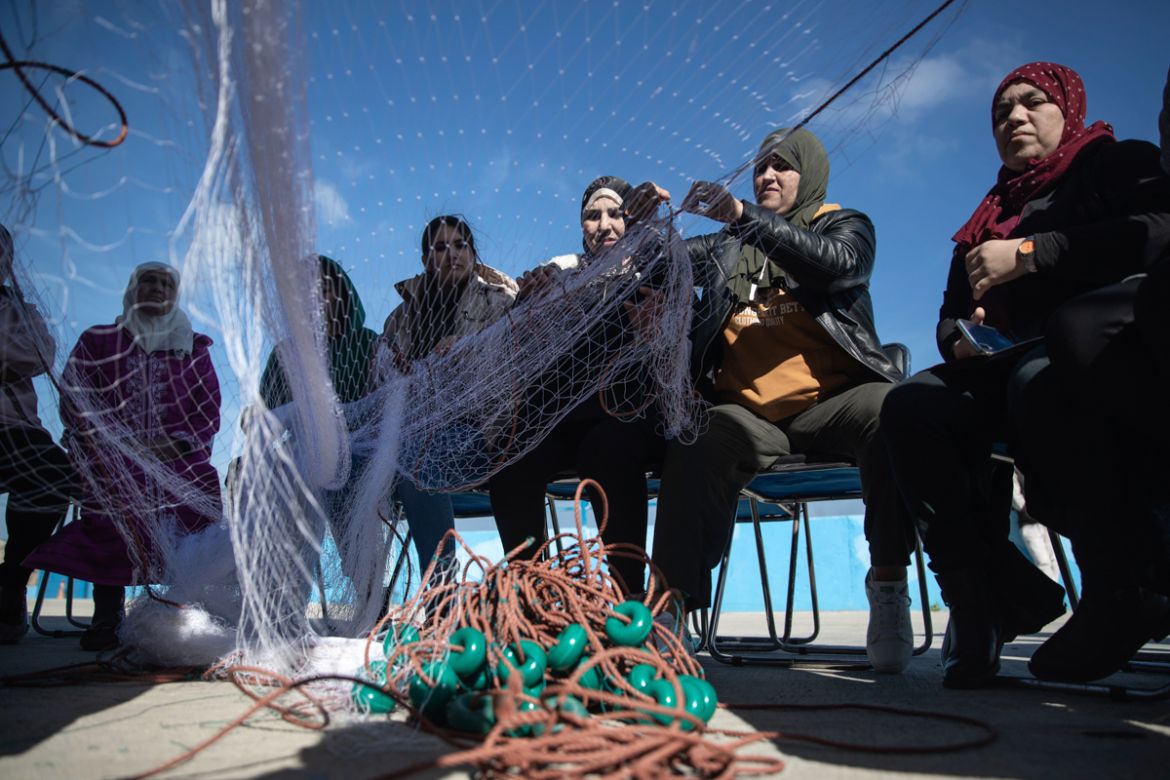 In this Tuesday, Feb. 11, 2020 photo, members of the first Moroccan female fishing cooperative prepare fishing nets before going out to sea, in the village of Belyounech on the coast of the Mediterran