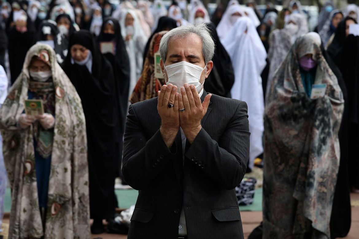 Worshippers wearing protective face masks offer Eid al-Fitr prayers marking the end of the Islamic fasting month of Ramadan, outside a mosque to help prevent the spread of the coronavirus, in Tehran,