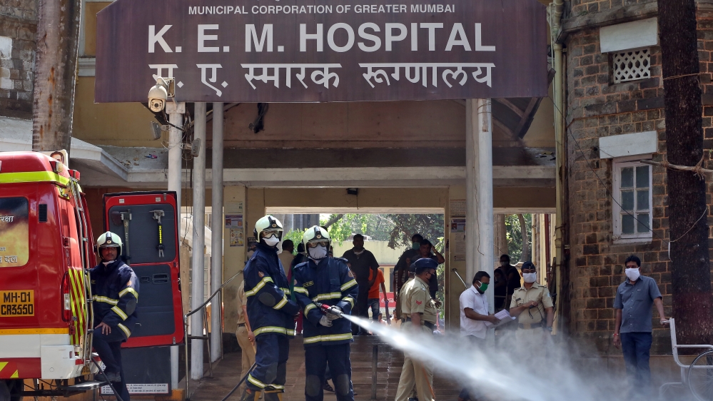 Firefighters disinfect the exteriors of a government-run KEM hospital, Mumbai