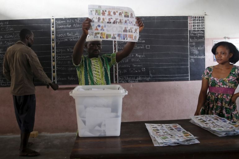 An electoral officer holds up a ballot paper during the count of votes after polling stations closed for the presidential election in Cotonou