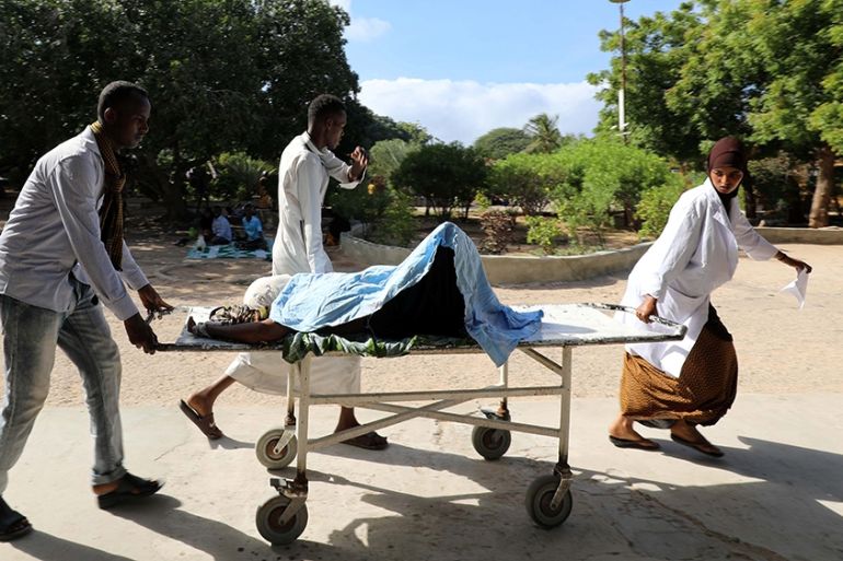 SENSITIVE MATERIAL. THIS IMAGE MAY OFFEND OR DISTURB A paramedic and civilians at Madina hospital assist an injured woman after a minibus struck a roadside bomb at Hawa Abdi village, northwest of Moga
