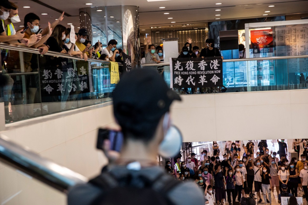 Pro-democracy demonstrators chant slogans in the Tsim Sha Tsui shopping mall calling for the city''s independence in Hong Kong on May 10, 2020. (Photo by ISAAC LAWRENCE / AFP)