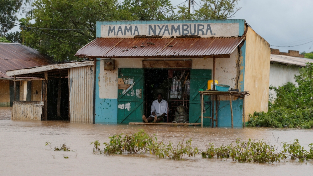 A trader sits at his shop as he looks at the food waters, after River Nzoia burst its banks and due to the backflow from Lake Victoria, in Buyuku village of Budalangi, in Busia County