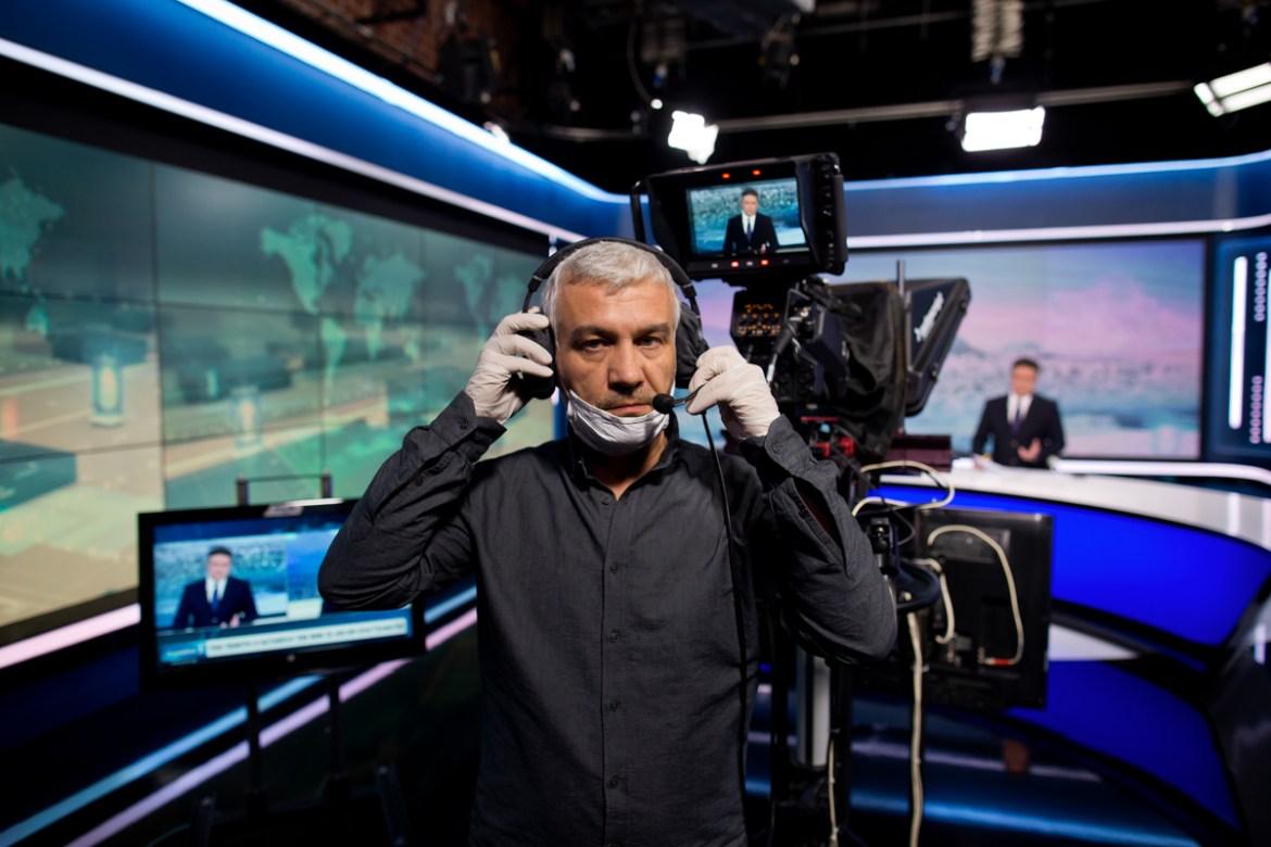 epa08392764 (11/13) Camera operator Giannis Mentzos, 49, wearing a protective face mask and gloves poses for a picture as he films a news anchor during the lockdown of the coronavirus disease (COVID-1
