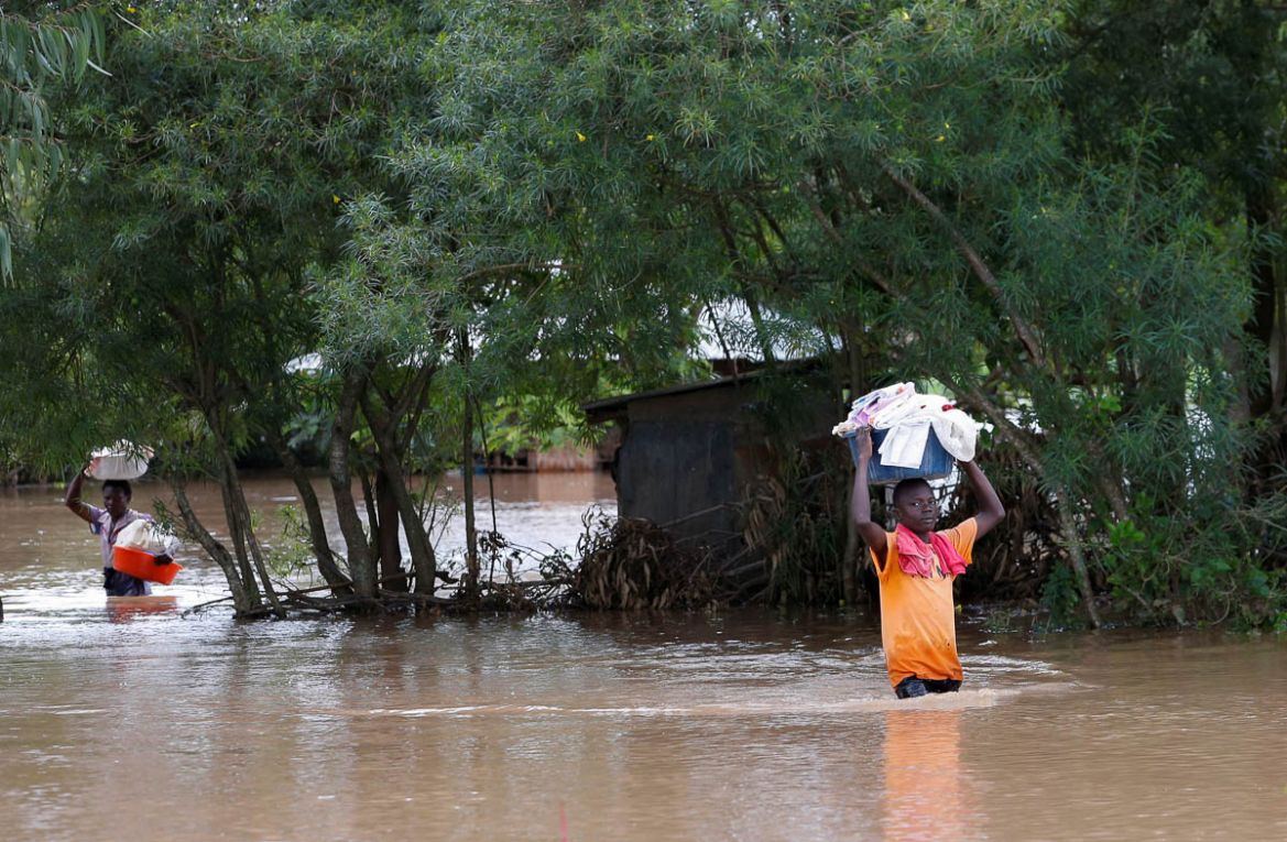 Residents carry their belongings as they evacuate from their home after River Nzoia burst its banks and due to the backflow from Lake Victoria, in Nyadorera, Siaya County, Kenya May 2, 2020. REUTERS/T