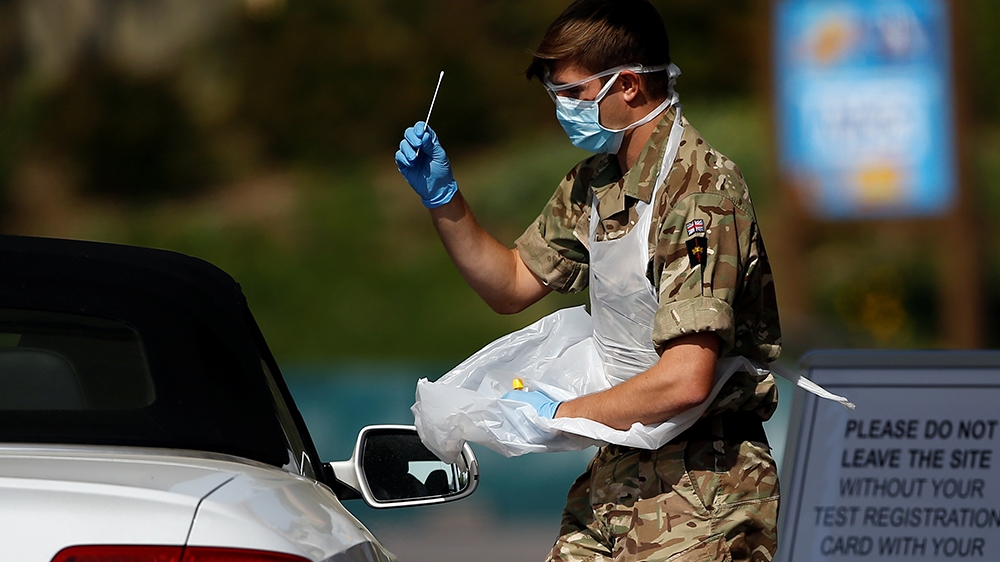 A member of the military conducts a coronavirus disease (COVID-19) check-up at a drive-thru testing site in Chessington, London, Britain, April 24, 2020. REUTERS/Henry Nicholls
