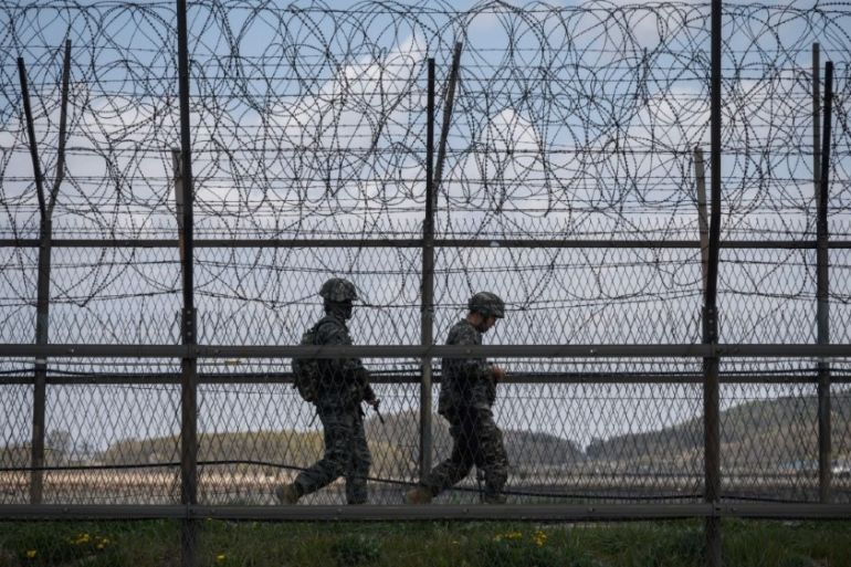 South Korean soldiers patrol along a barbed wire fence Demilitarized Zone (DMZ) separating North and South Korea, on the South Korean island of Ganghwa on April 23, 2020.