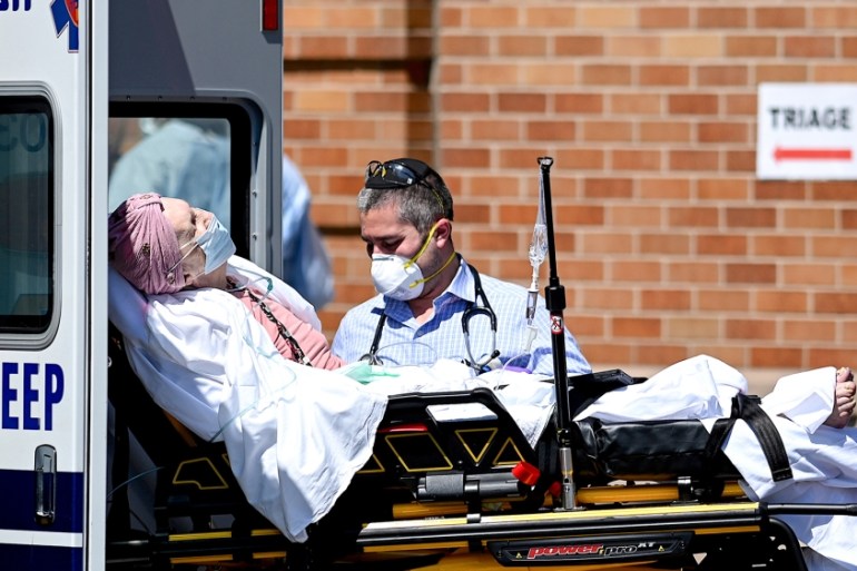 Medical workers transport a patient outside a special COVID-19 area at Maimonides Medical Center on May 14, 2020 in the Borough Park neighborhood of Brooklyn in New York City. (Photo by Johannes EISEL