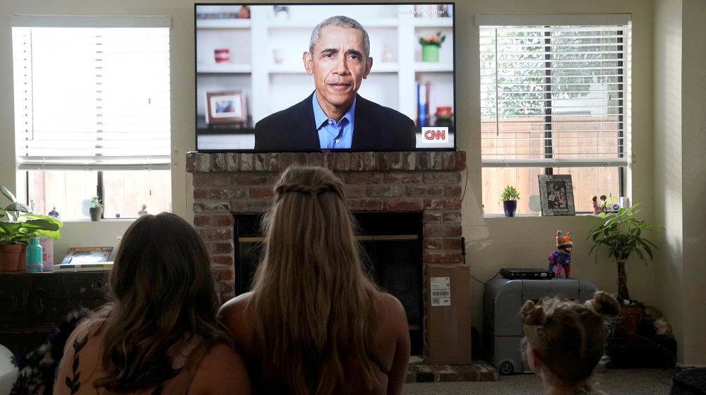 Torrey Pines High School graduating student Phoebe Seip (18, center), and her sisters Sydney (22, left) and Paisley, 6, watch former U.S. President Barack Obama deliver a virtual commencement address 
