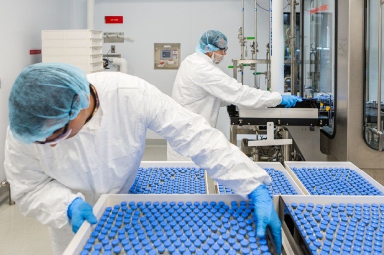 Lab technicians load filled vials of investigational coronavirus disease (COVID-19) treatment drug remdesivir at a Gilead Sciences facility in La Verne, California, U.S. March 18, 2020.