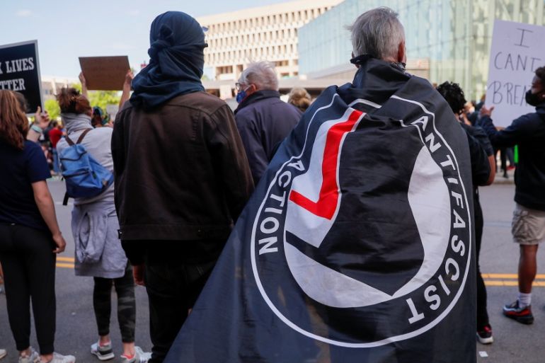A protester carries an Antifascist Action flag at a rally following the death in Minneapolis police custody of George Floyd, in Boston, Massachusetts, U.S., May 31, 2020. REUTERS/Brian Snyder