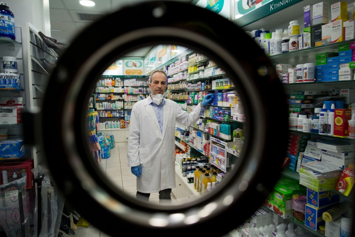 epa08392757 (04/13) Pharmacist Labros kouris, 42, wearing a protective face mask and gloves poses for a picture inside his pharmacy, during the lockdown of the coronavirus disease (COVID-19) outbreak,