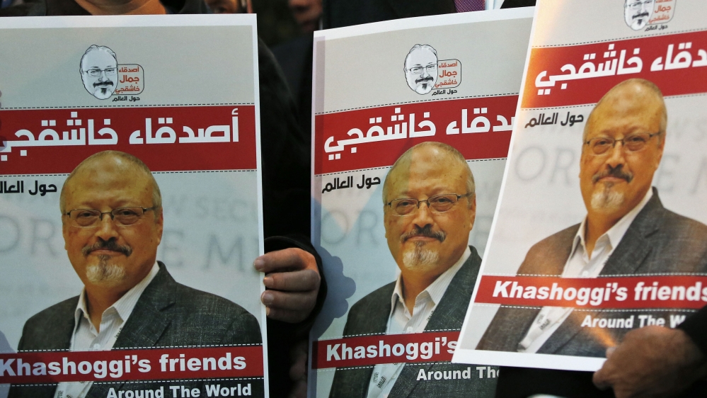 Activists protesting the killing of Saudi journalist Jamal Khashoggi hold a candlelight vigil outside Saudi Arabia's consulate in Istanbul, Thursday, Oct. 25, 2018. The posters read in Arabic:' 